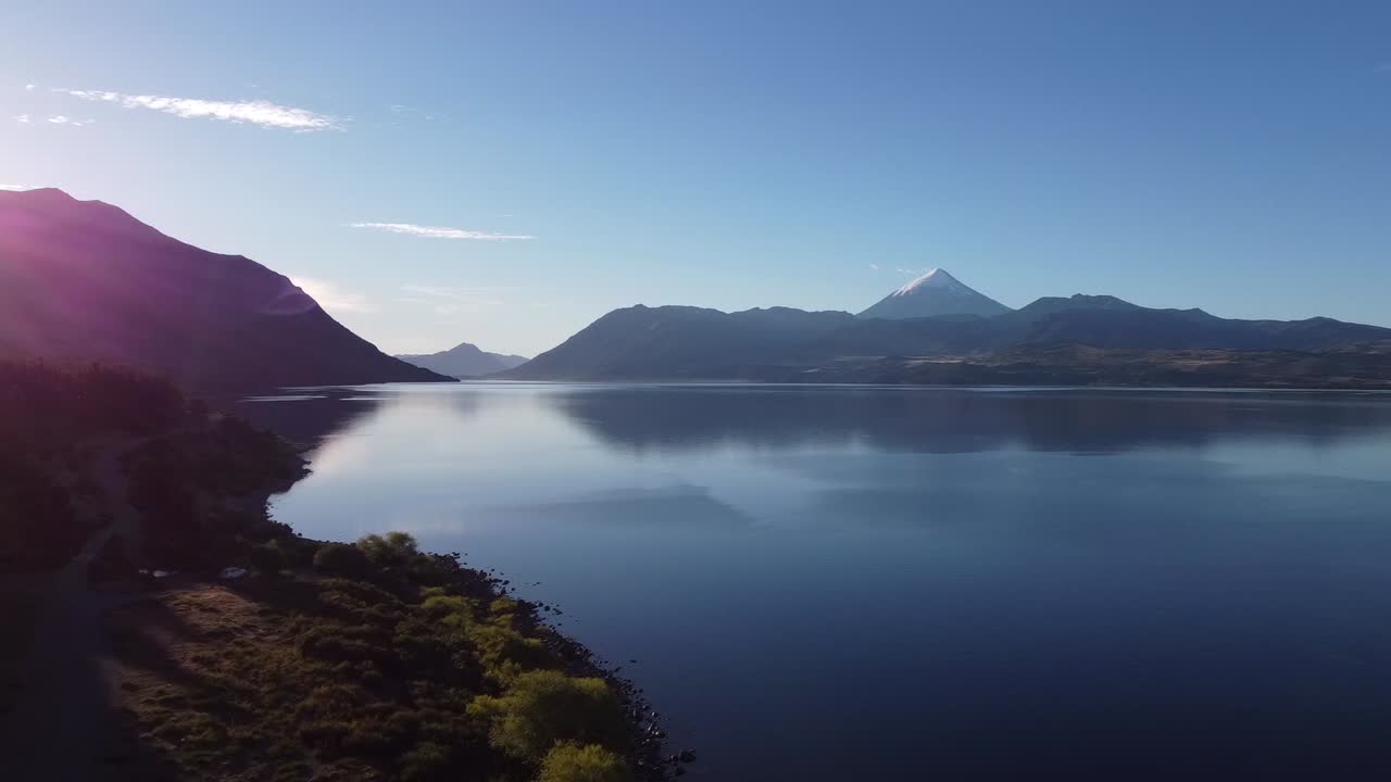 aereal pan shot of stunning lighting and scenario in Huechulafquen Lake in Argentina with Lanin Volcano nexto to it