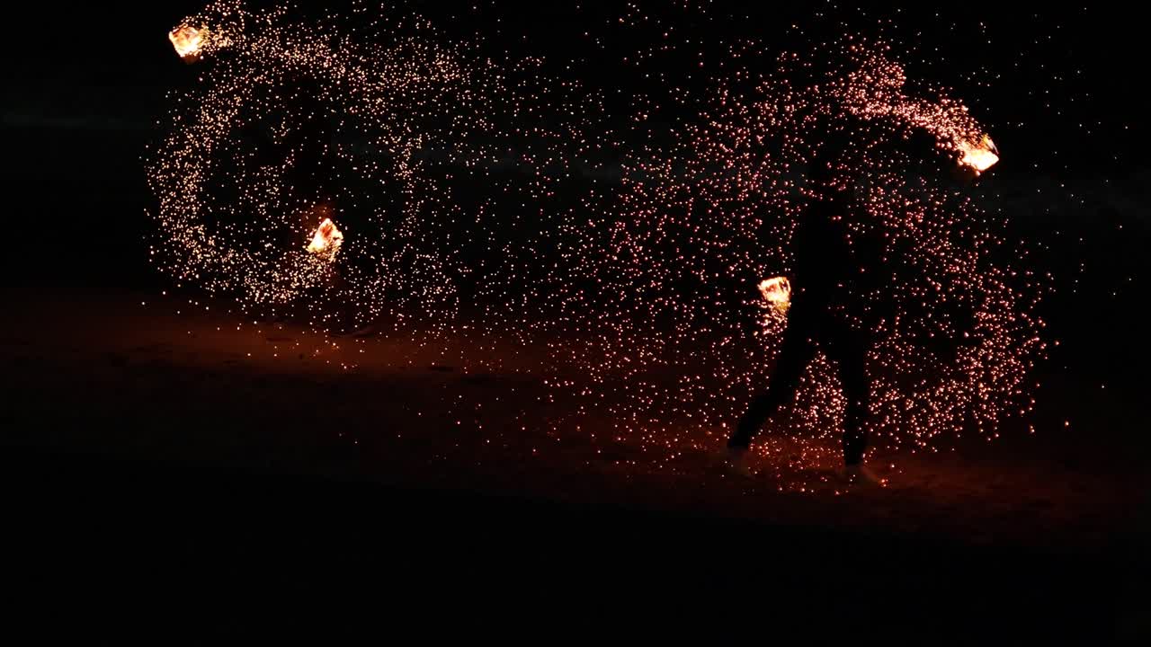공연자는 불을 회전시켜 매혹적인 빛 패턴을 만니다.