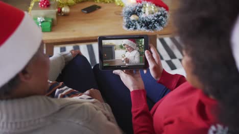 Madre-E-Hija-Afroamericanas-Usando-Una-Tableta-Para-Una-Videollamada-Navideña-Con-Un-Niño-En-La-Pantalla