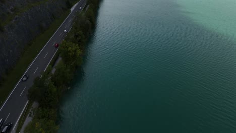 scenic lakeside road with cars driving alongside mondsee in austria, captured from an aerial view