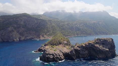 flying towards a cloudy mountain bay on mallorca island with yacht´s anchor