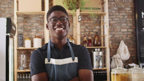 Portrait-Of-Male-Owner-Of-Sustainable-Plastic-Free-Grocery-Store-Behind-Sales-Desk