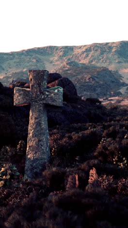 cruz de piedra en un cementerio en una colina