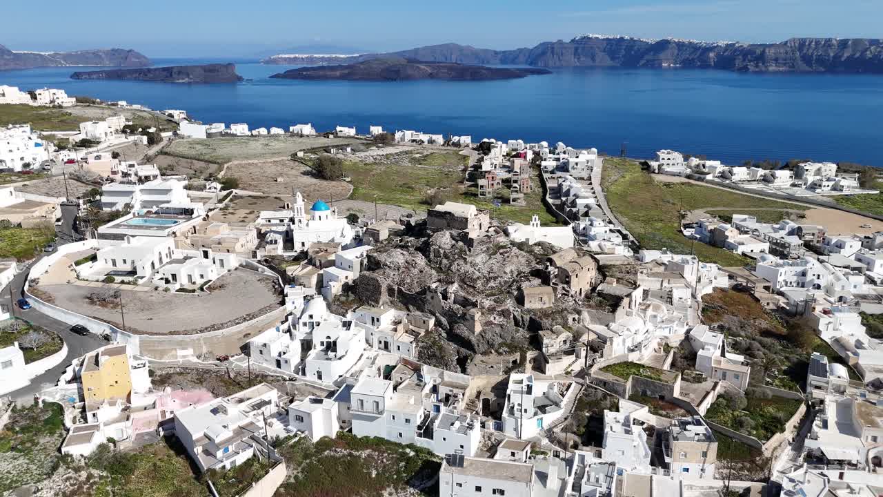 Panorama aéreo de drone da vila caiada de Oia em Santorini, Grécia. A arquitetura cicládica clássica fica no topo de falésias vulcânicas com vista para as profundas águas do Mediterrâneo.
