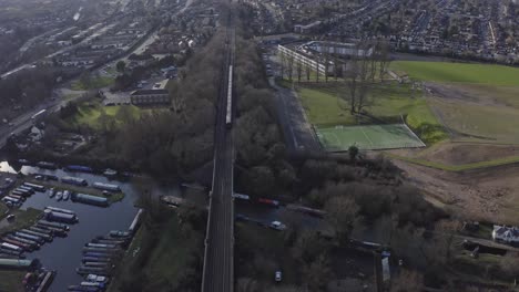 cinematic pan down drone shot of london metropolitan line train in suburban uk watford