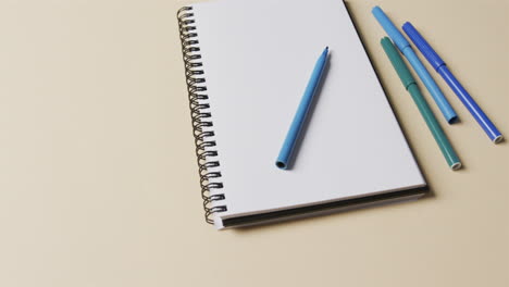 capa plana de cuaderno y marcadores con espacio de copia sobre fondo amarillo