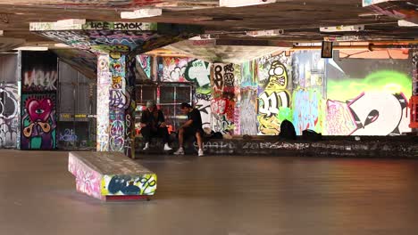 skater performs trick in graffiti-covered alley