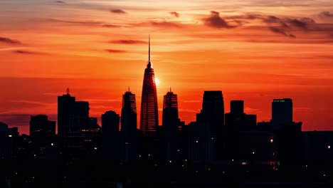 the sun rises behind the petronas towers in kuala lumpur, malaysia, bathing the city in a warm, orange glow