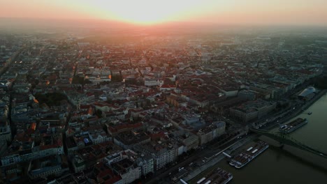 Sunrise over Budapest skyline with city lights fading as golden light spreads over rooftops, cityscape backdrop along Danube River
