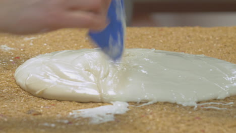 soft icing mix is drizzled on top of flapjack slice ready to be spread out