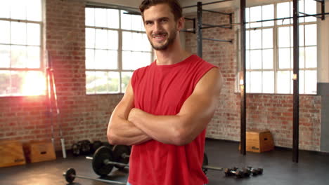 Hombre-En-Forma-Sonriendo-A-La-Cámara-En-El-Gimnasio