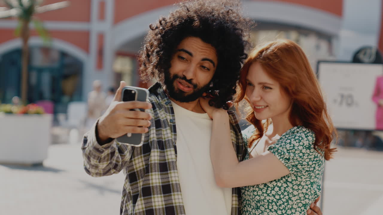 pareja feliz tomando selfies en un centro comercial de la ciudad
