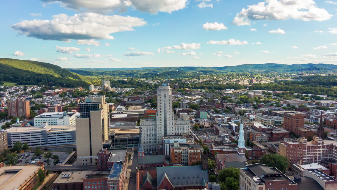 Aerial orbit of American urban downtown metropolis city center, timelapse, hyperlapse, Reading PA USA, financial district, office buildings, church steeple, apartments, businesses, homes, urban center