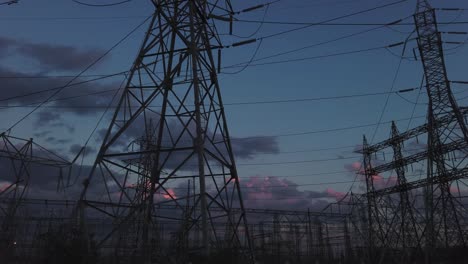 amplia, al final del día, toma panorámica de derecha a izquierda de la infraestructura de la red eléctrica con una suave inclinación hacia la torre grande