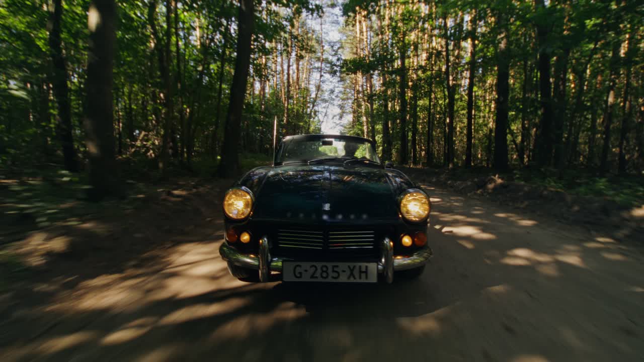 Oldtimer fährt durch den Wald
