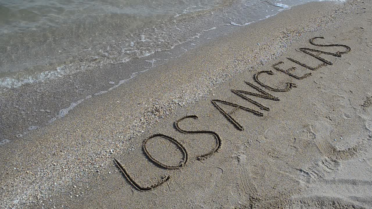 Inscription on the beach. Shooting on the beach. Shooting on the beach