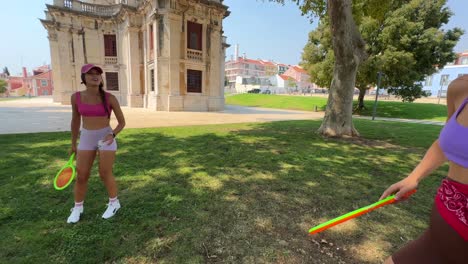 Two Women Playing Matkot in a Park