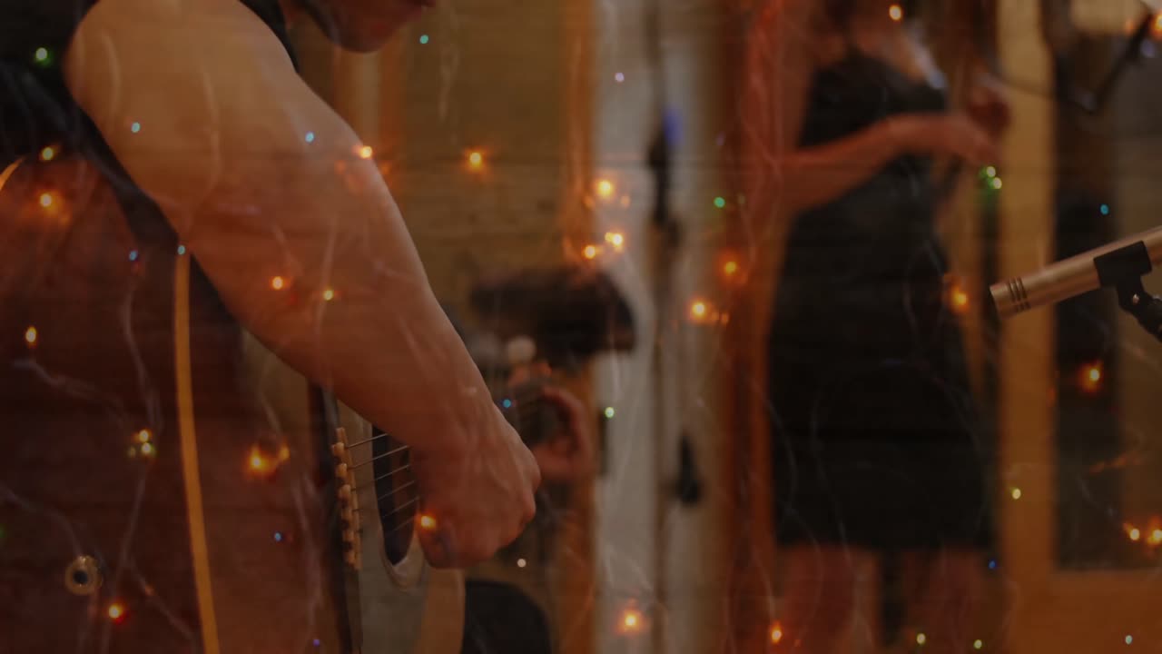 Punti luminosi di luce sullo sfondo di un uomo che suona la chitarra