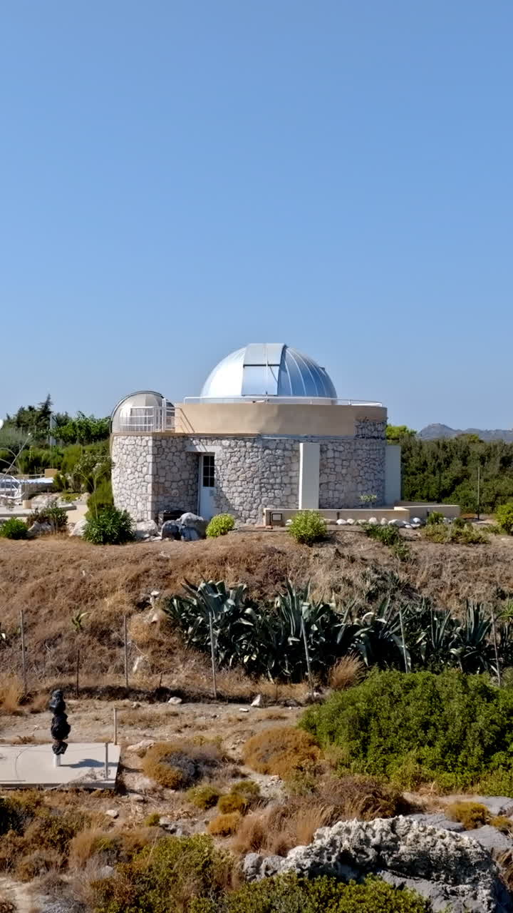 Vertical drone shot toward the Faliraki observatory, sunny day in Rhodes, Greece