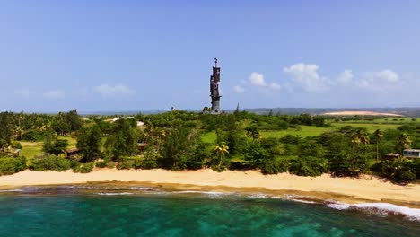 hermosa playa, con palmeras, agua azul y la estatua de cristóbal colón