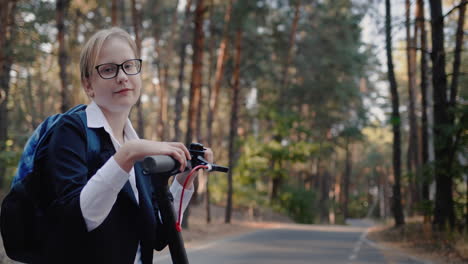 portrait of a child in school uniform with a scooter