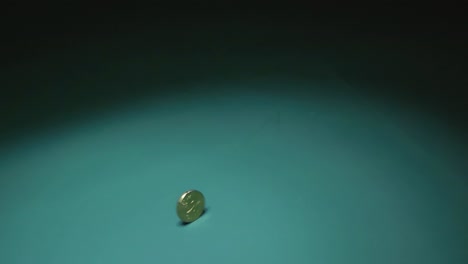 las imágenes muestran una moneda de 20 centavos de euro girando rápidamente sobre un fondo verde vibrante