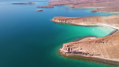 Aerial:-tropical-Pacific-Ocean-coastline,-yacht-moored-off-Baja-California-Sur