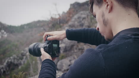retrato de un fotógrafo que toma una foto del paisaje usando el modo de vista en vivo en la cámara