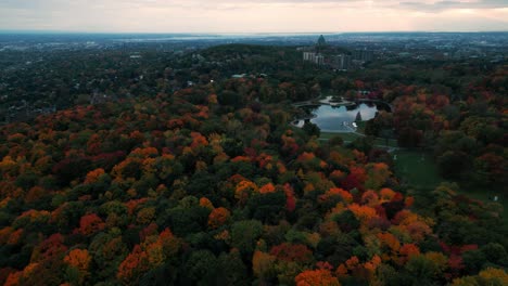 drone disparado sobre el mont royal parc en montreal durante el otoño con árboles coloridos, lac aux castors y el oratorio de san josé en el fondo