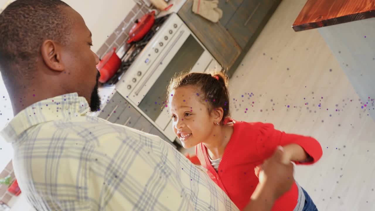 Dad grabbing girl's hand, guiding spins in kitchen while sparkles around them, building family bond