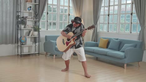 asian boy playing guitar, sing a song and dancing at living room