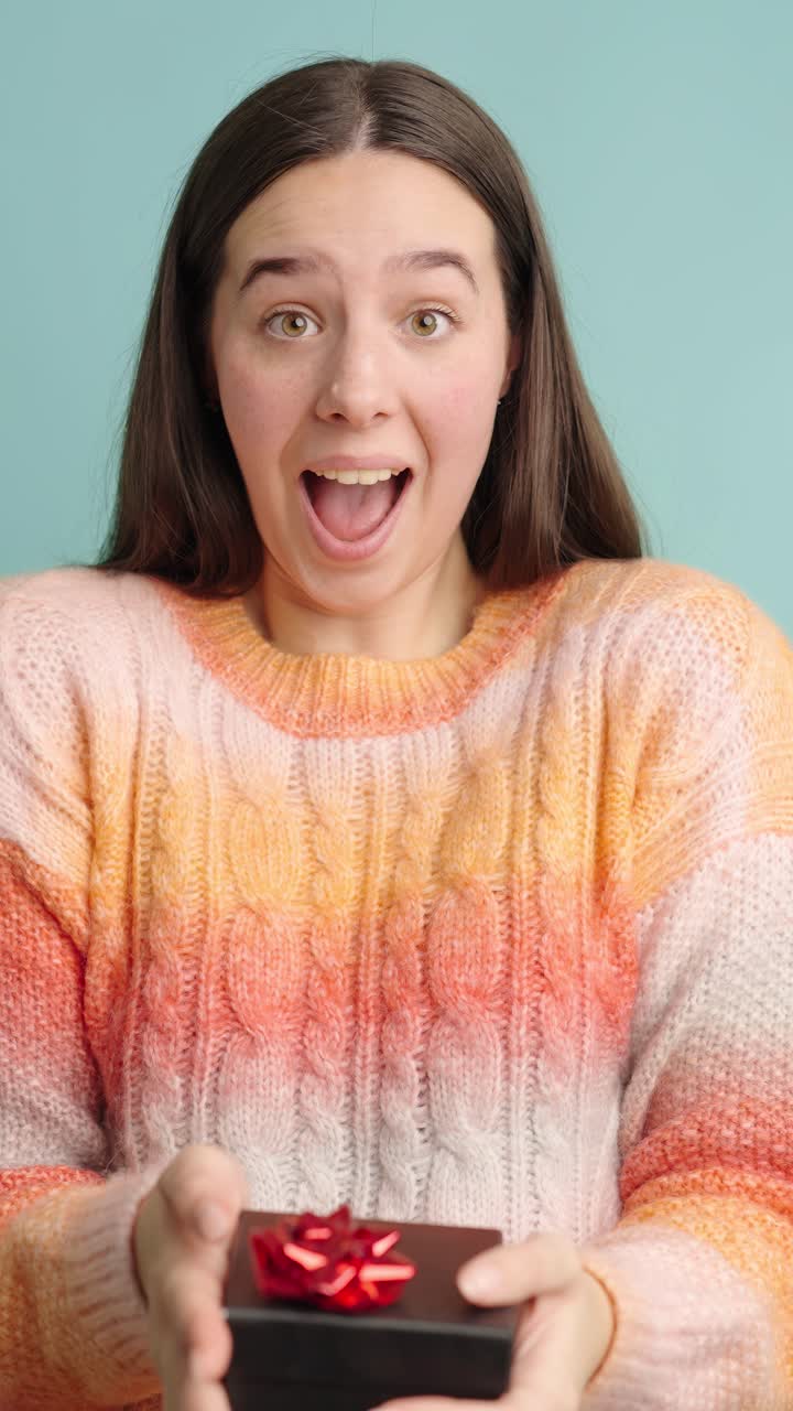 Woman expressing joy while receiving a gift box surprise