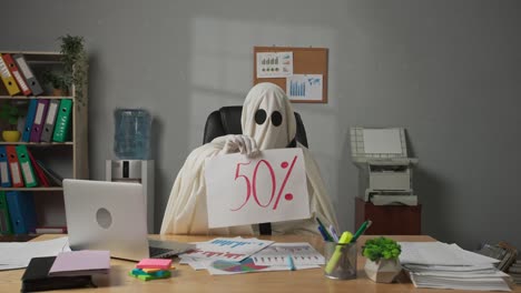 a ghost in an office holding a '50%' sign
