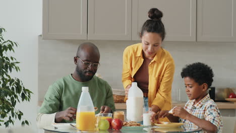 happy african american family having breakfast at home