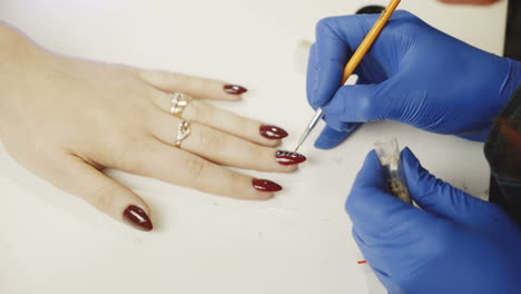 manicure. beautiful well groomed nails of a woman are decorated with rhinestones. close-up