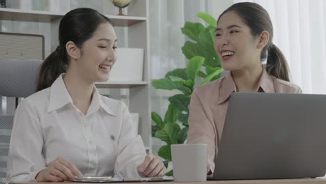 two young enthusiastic businesswoman working together in the office workspace.