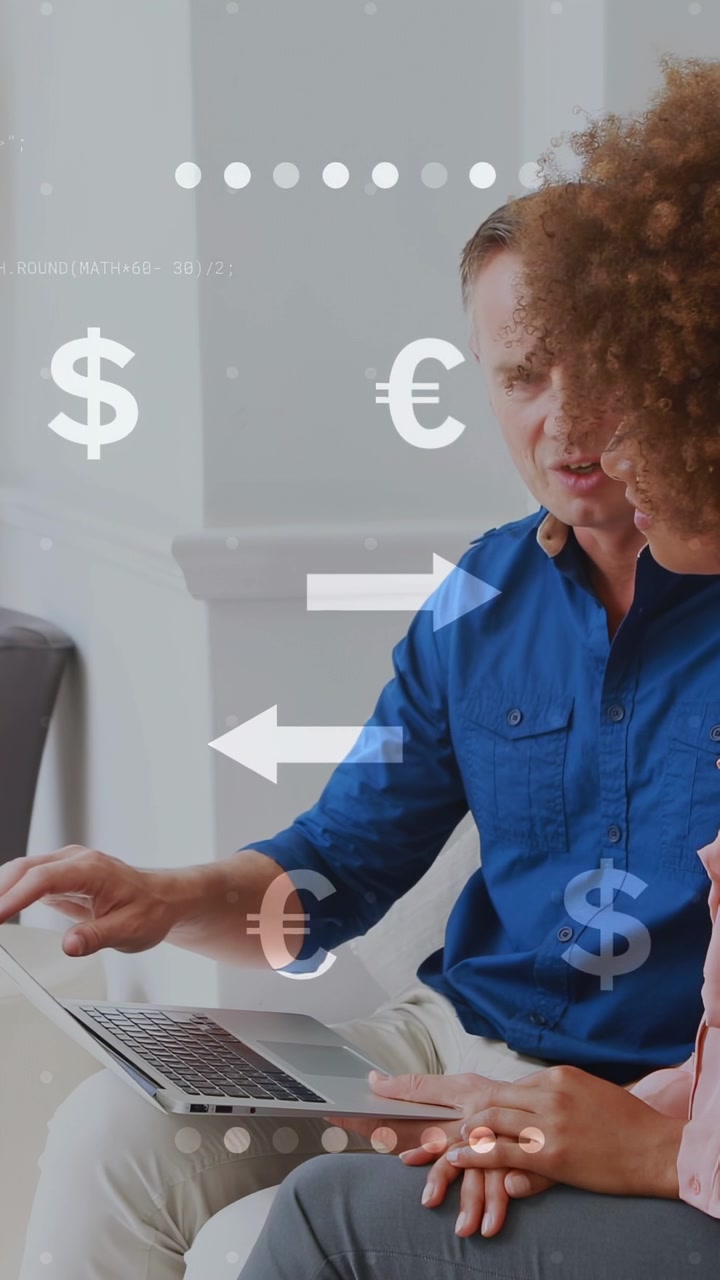 Video verticale: Coppia sul divano che esamina le finanze sul laptop, con l'uomo che tocca un pad e fa apparire frecce finanziarie.