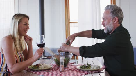 happy caucasian mature couple smiling, talking and enjoying meal together