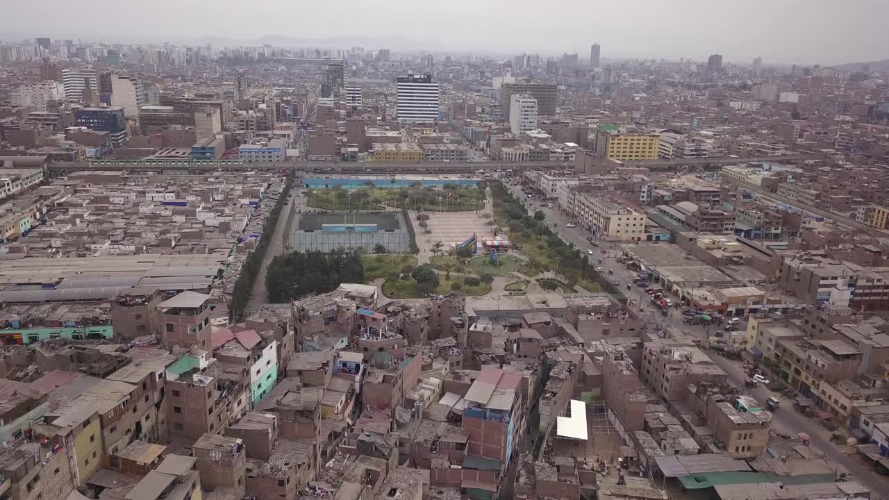 An aerial cityscape showcasing a green park amidst dense urban housing and commercial streets. Ideal for editorial use, urban studies, and stock photography.