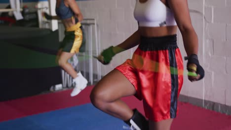 dos mujeres de raza mixta trabajando en el gimnasio de boxeo