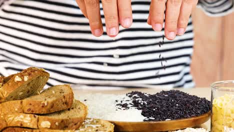 hands organize various grains and bread slices on a wooden board. bright lighting highlights the textures and colors