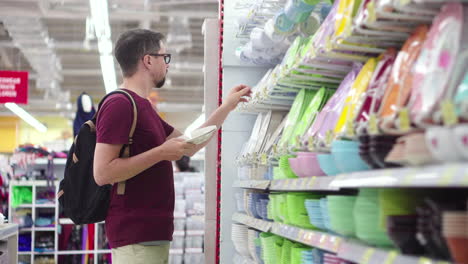 hombre comprando vajilla en un supermercado