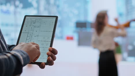 financiero agente inmobiliario y cliente examinando planos en una tableta