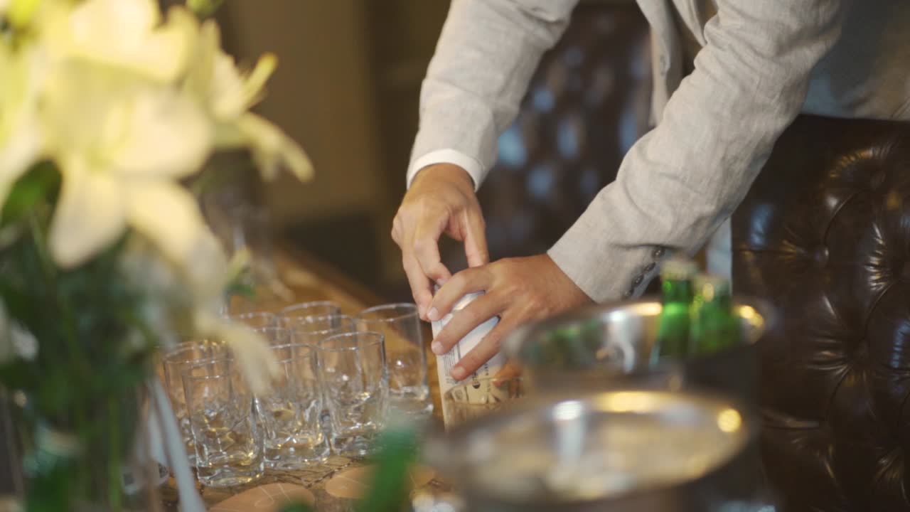 Hands of a man opening a canned drink on a bar table at a wedding reception