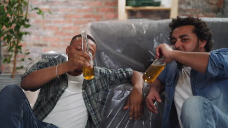 amigos negros felices celebran la reparación y terminan bebiendo cerveza.