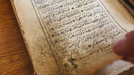 Footage of a person leafing through an hundred year old Quran