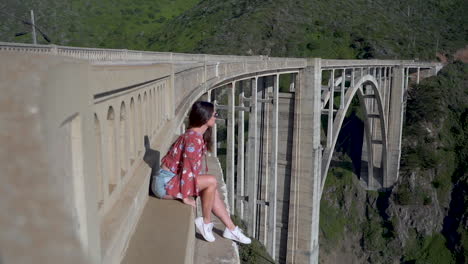 niña sentada en el borde del puente, admirando la vista del parque nacional en california