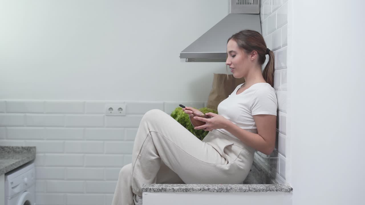 Woman Eating in a Modern Kitchen