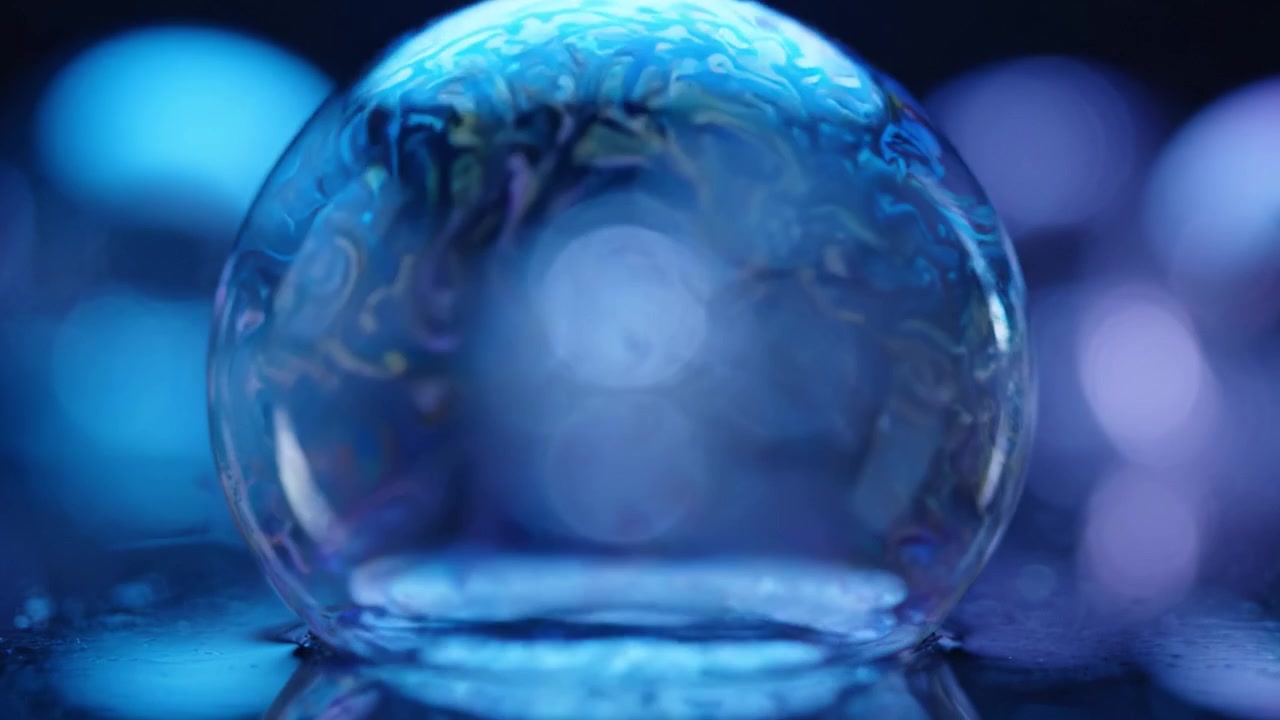 Primo piano accattivante di una bolla di sapone eterea che riflette un'atmosfera sognante in una miscela abbagliante di sfumature blu e viola.