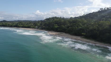 aerial orbit overview of punta cocles coastline in puerto viejo, costa rica with stunning calm beachs and crashing waves in tropical setting